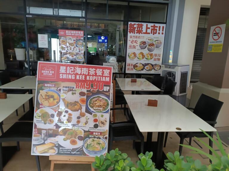 Shing Kee Kopitiam exterior with menus and outdoor dining area.