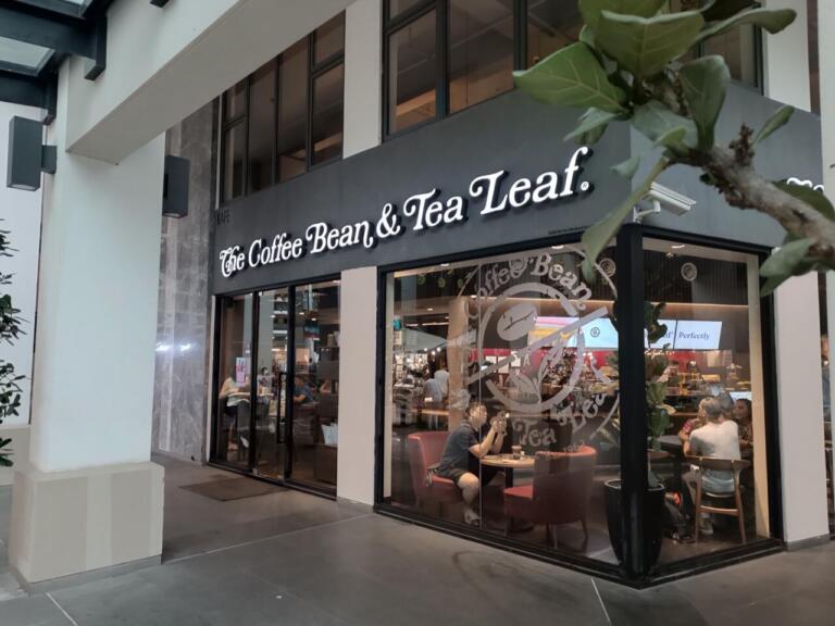 The Coffee Bean & Tea Leaf cafe exterior with customers inside.
